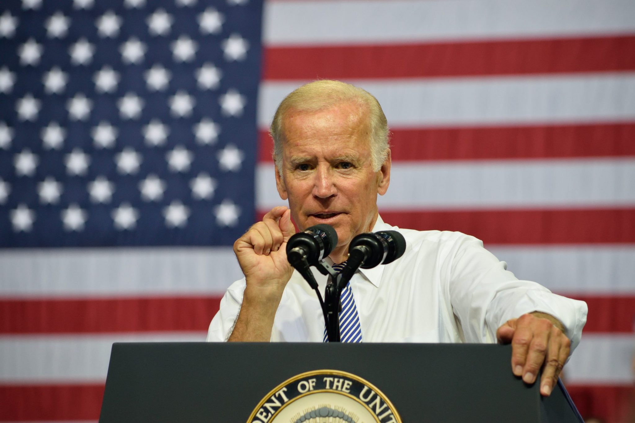 Joe Biden delivers a speech in front of an American flag