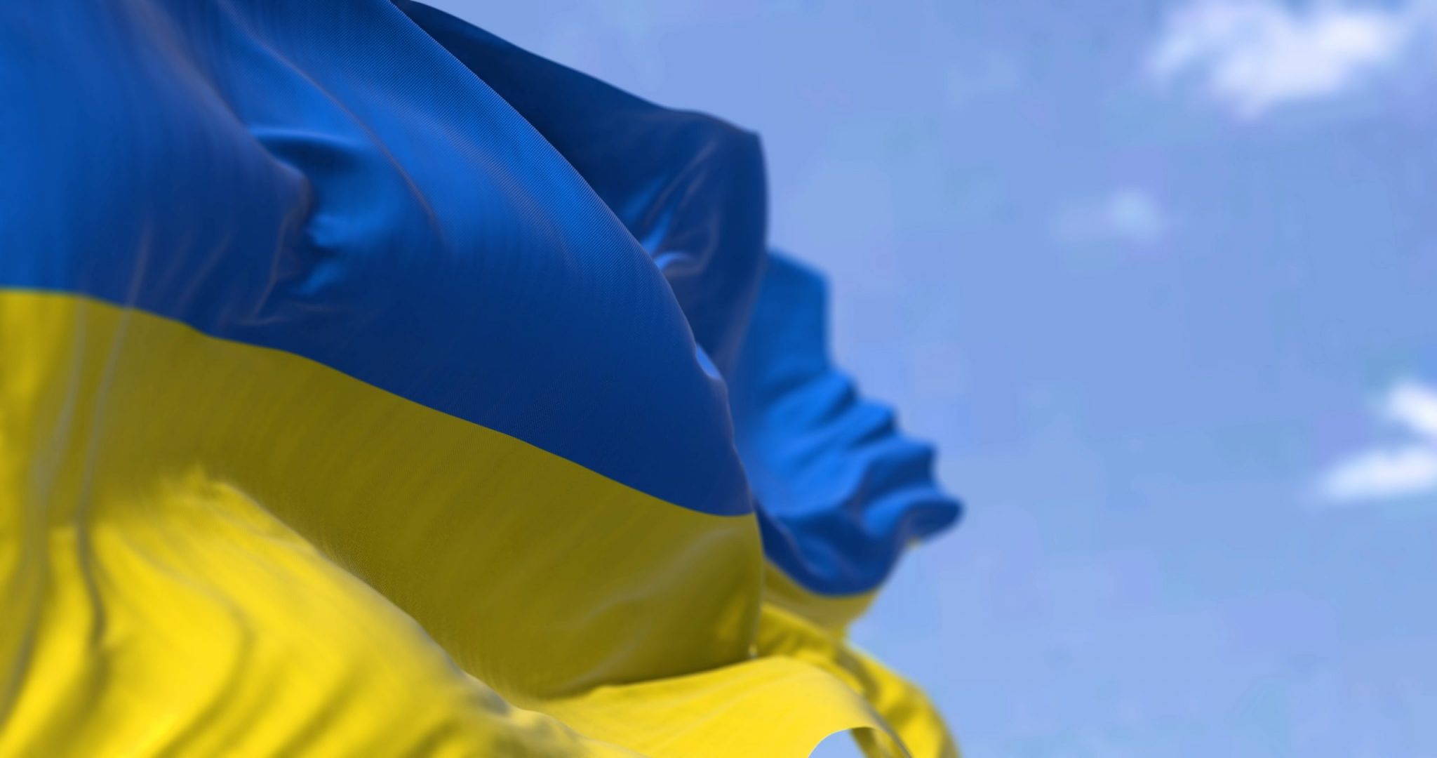 Detail of the national flag of Ukraine waving in the wind on a clear day.