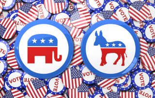 Republican and Democratic symbols on top of vote and american flag pins