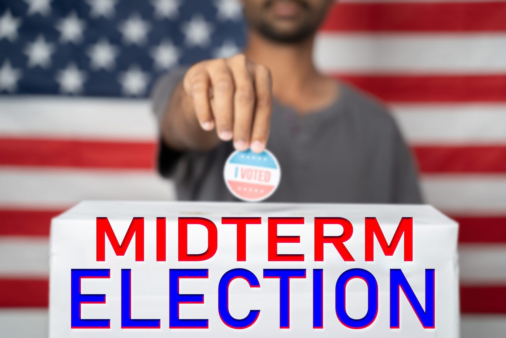focus on Midterm election, Concept of 2022 American Midterm Elections showing by placing I voted sticker on ballot box with Midterm Election sign in front of US flag