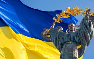 Monument of Independence of Ukraine in front of the Ukrainian flag