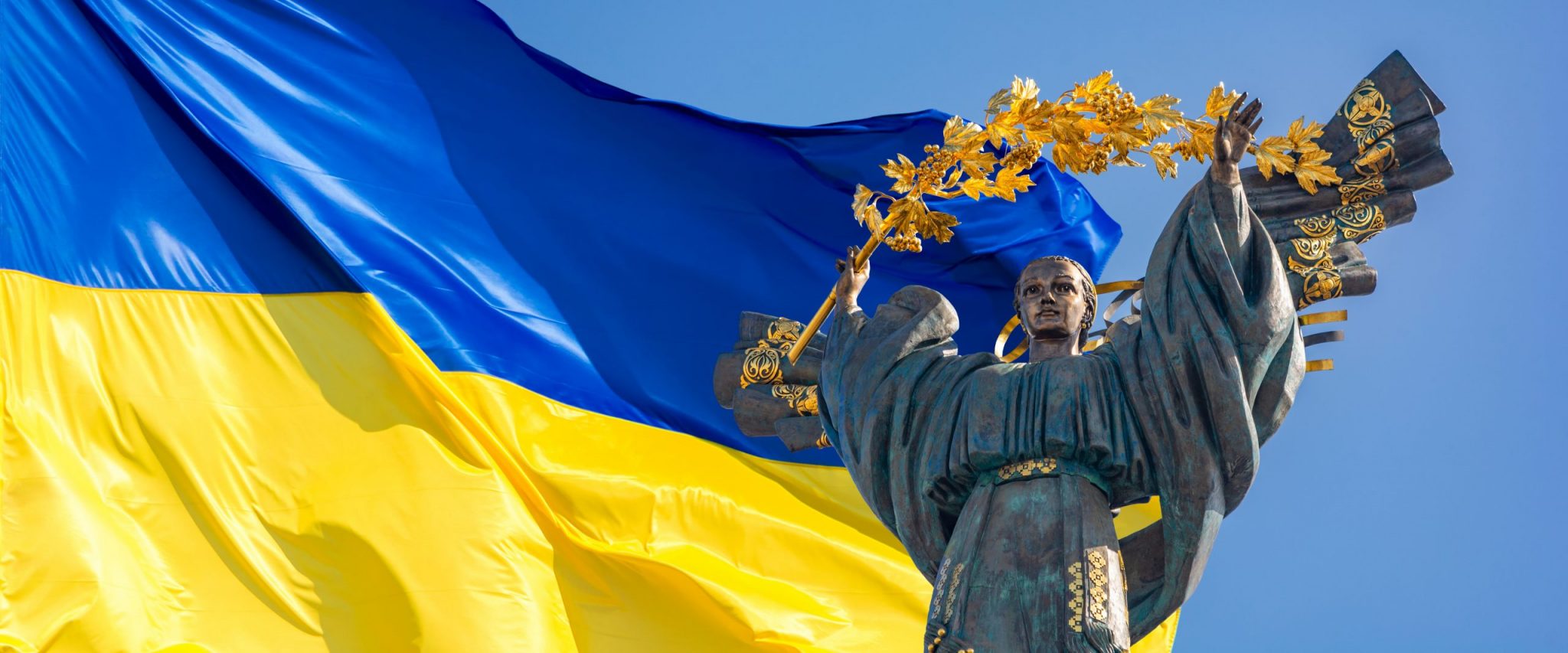 Monument of Independence of Ukraine in front of the Ukrainian flag