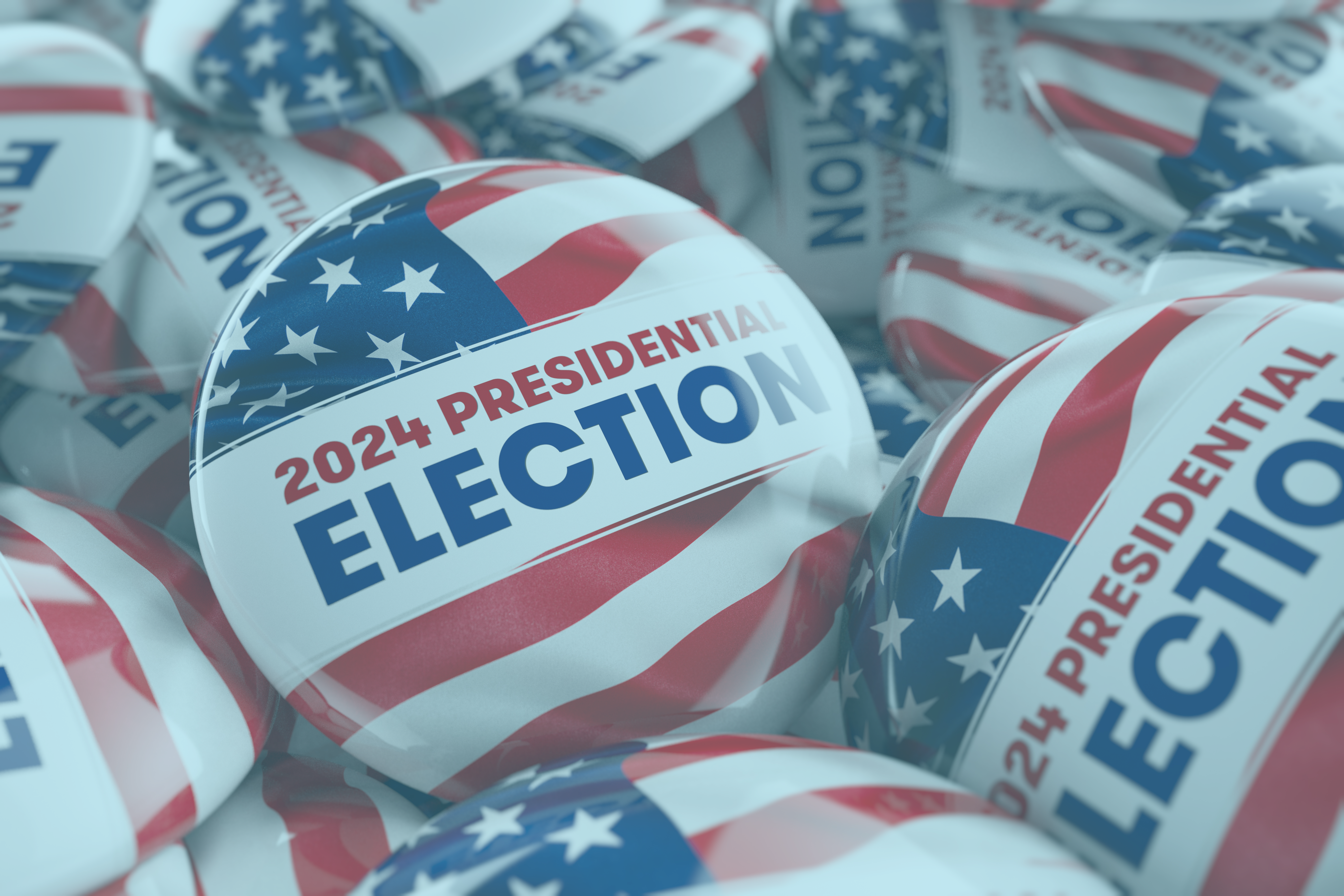 Closeup shot of one presidential election 2024 button in focus in between many other buttons in a box