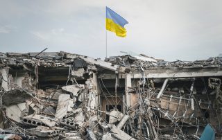 the wreckage of the building and the Ukrainian flag
