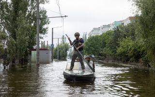 KHERSON, UKRAINE - Jun. 12, 2023: Volunteers and rescuers move by boat through flooded streets of Kherson