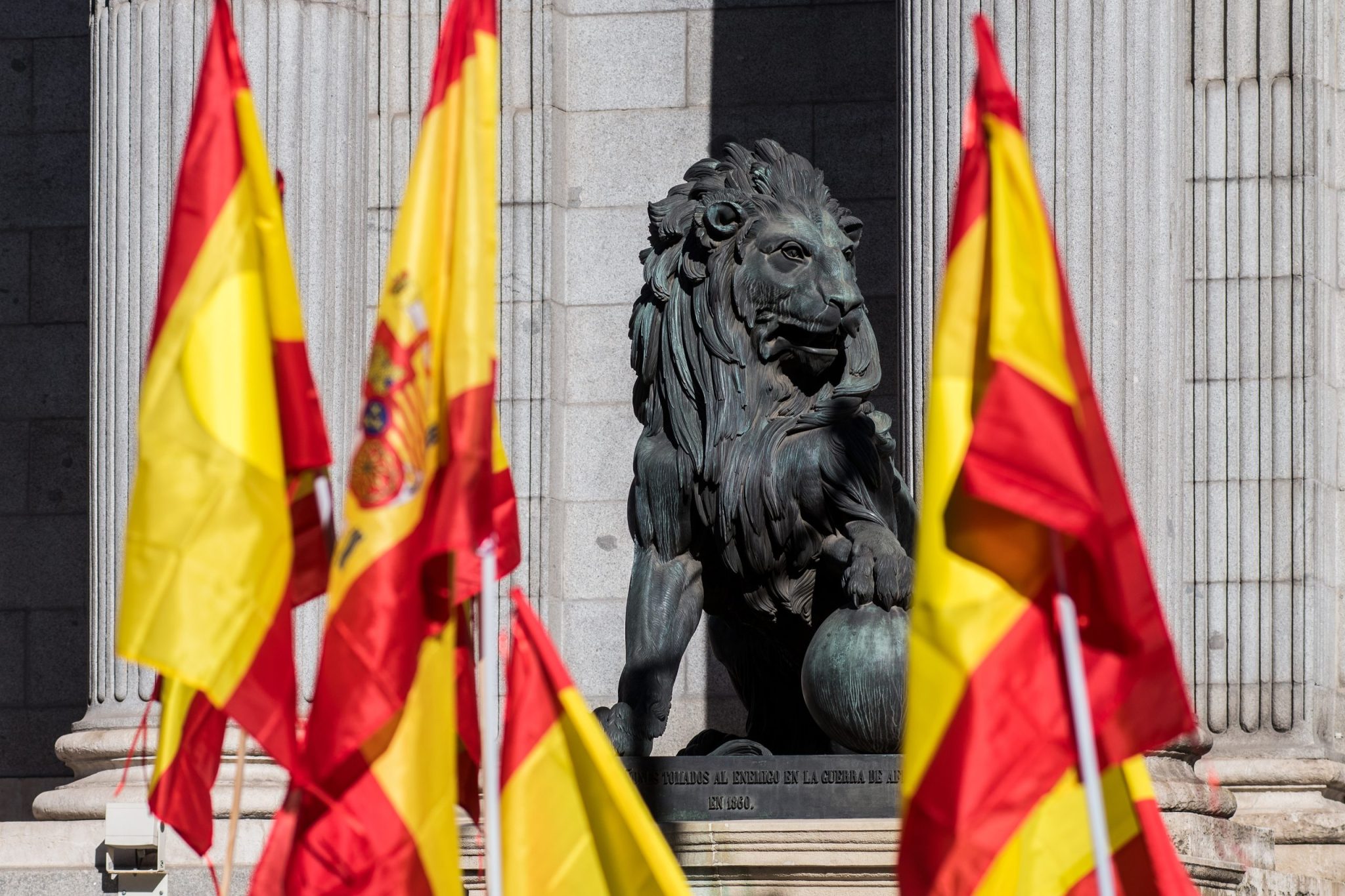 Sculpture of lion in the Congress of Deputies of Madrid with Spanish flags